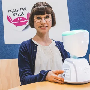 Mädchen mit Pagenkopf und einem weißen Kunststoffgerät
