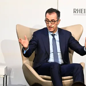 Minister Özdemir sitzt in einem Sessel, er gestikuliert mit beiden Händen