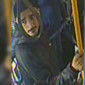 Aufnahme aus der Überwachungskamera eines Busses: ein junger Mann mit schwarzem Oberlippenbart und schwarzer Basecap
