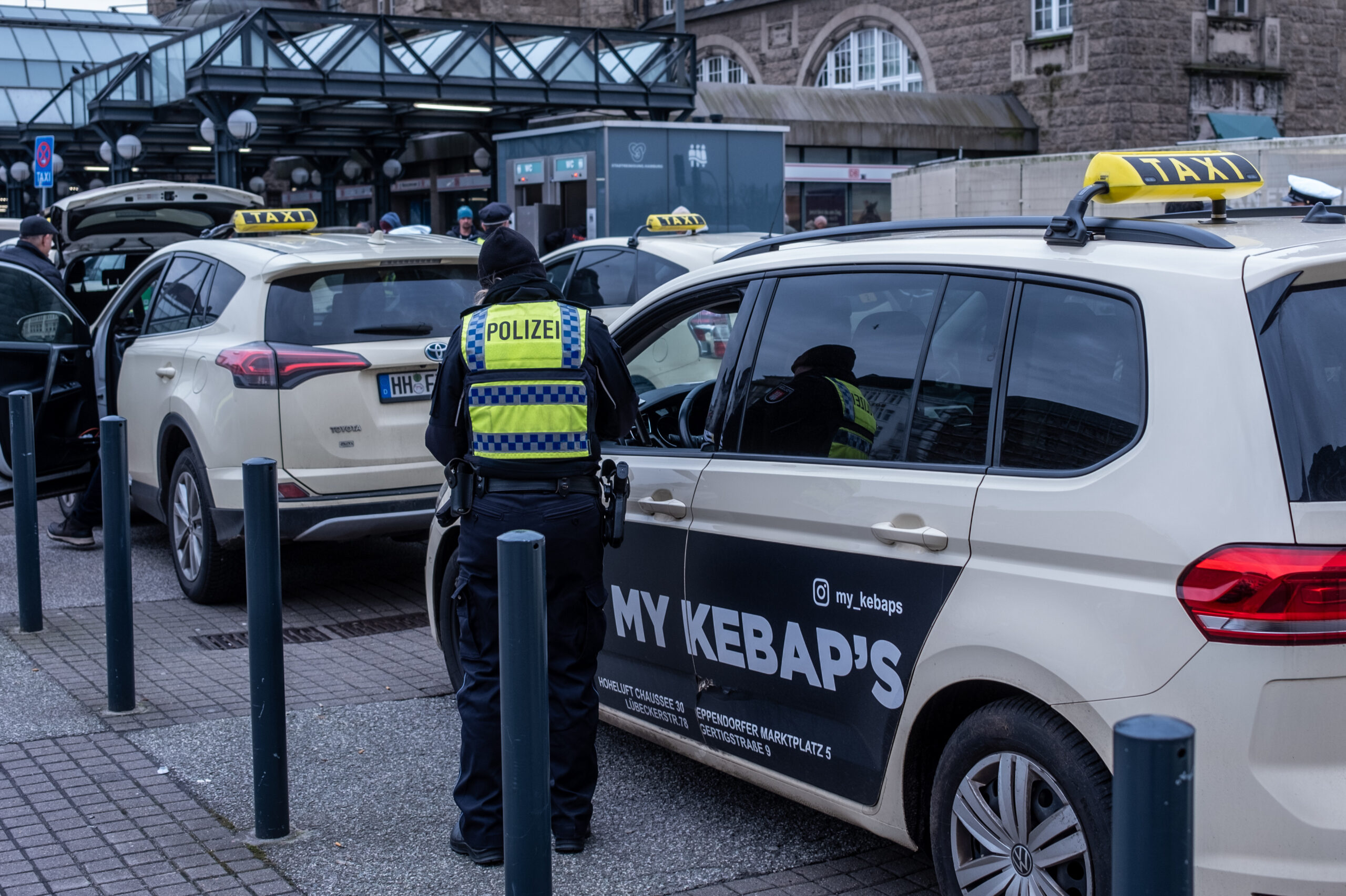 Eine Polizistin kontrolliert ein Taxi am Hamburger Hauptbahnhof.