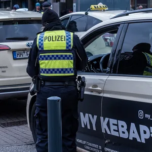 Eine Polizistin kontrolliert ein Taxi am Hamburger Hauptbahnhof.