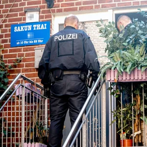 Polizisten stehen vor einer Tür