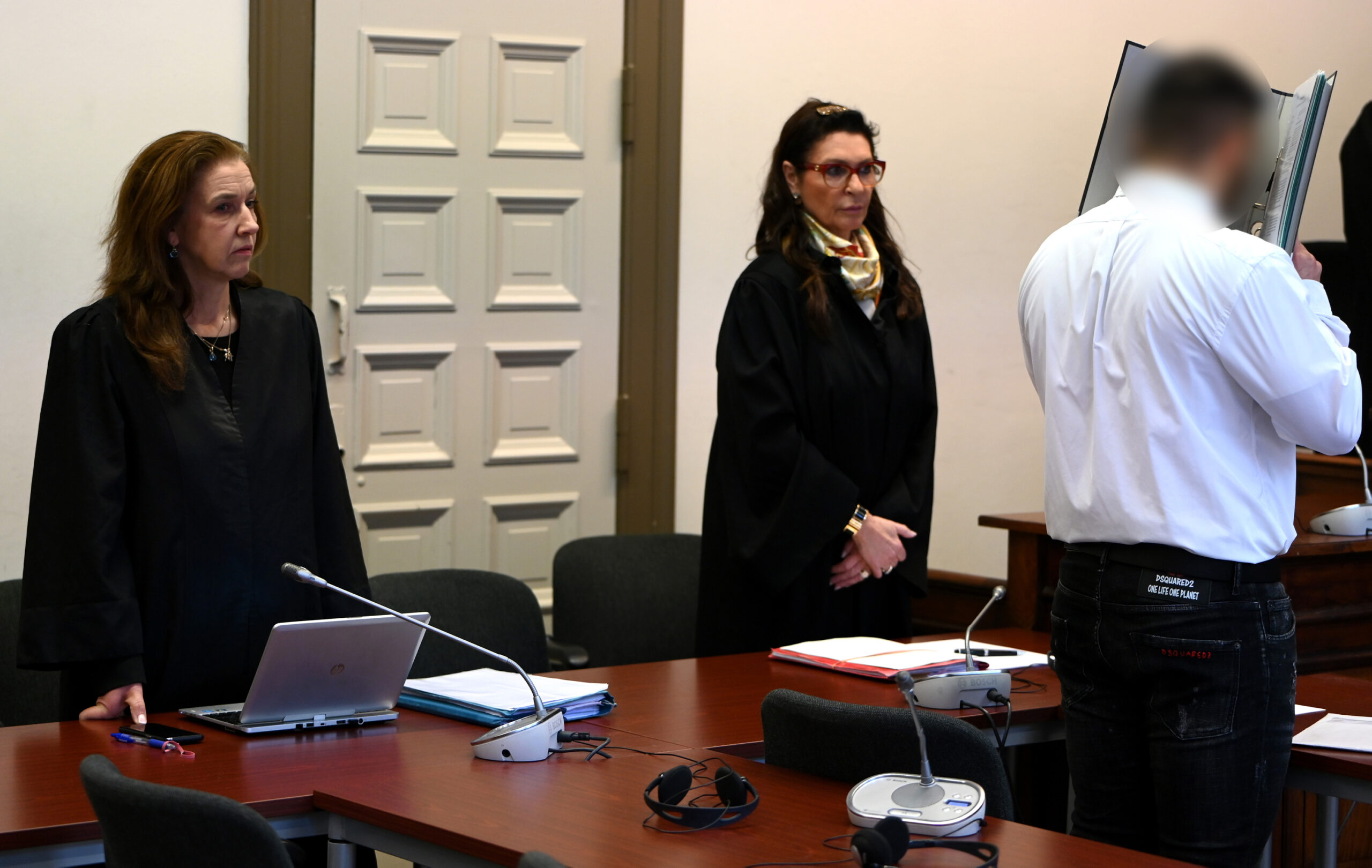 Der Angeklagte steht neben seinen Anwältinnen Jutta Heck und Bettina von Hindte zu Beginn des Prozesses.