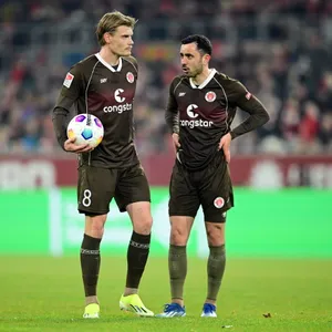 Eric Smith (l.) und Manolis Saliakas stehen auf dem Feld nebeneinander und warten.