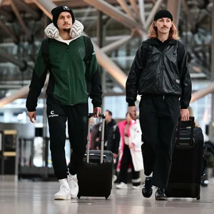 Adam Dzwigala und Jackson Irvine am Flughafen mit ihren Koffern.