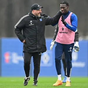 Steffen Baumgart klopft Bakery Jatta im HSV-Training lächelnd auf die Schulter