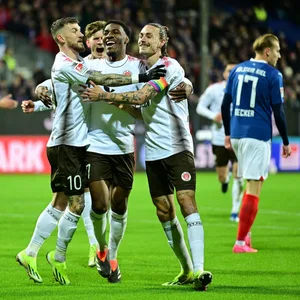 Die St. Pauli-Profis Hartel, Afolayan und Irvine bejubeln die 1:0-Führung in Kiel.