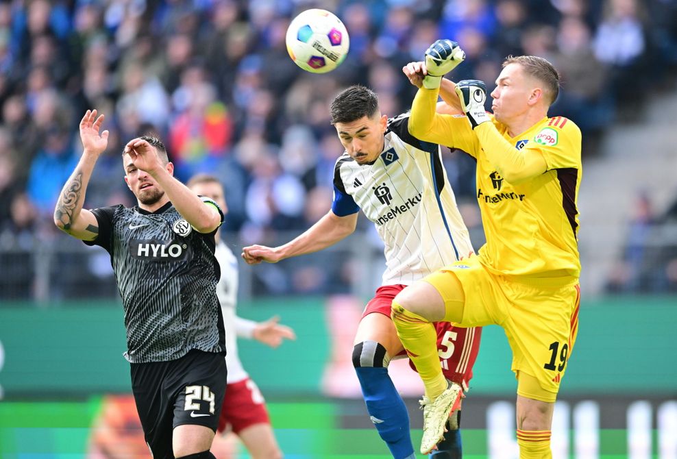 Dennis Hadzikadunic (M.) und Matheo Raab (r.) rasseln bei einer Flanke ineinander.