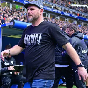 Steffenb Baumgart mit HSV-Schiebermütze und „Moin“-Shirt: