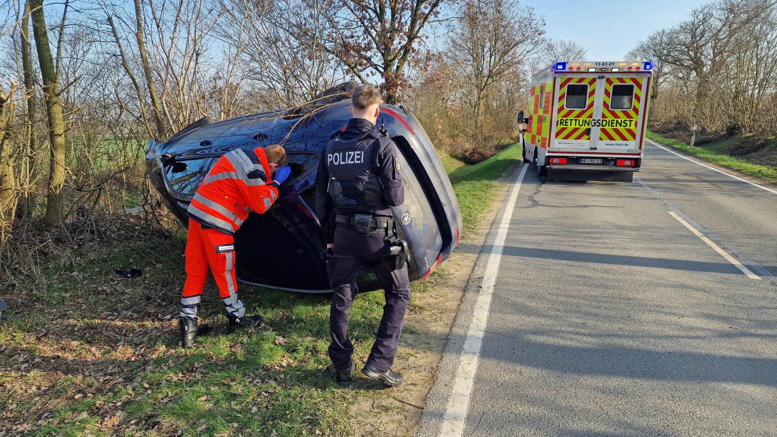 Ein Sanitäter spricht mit der Frau durch ein offenes Fenster.