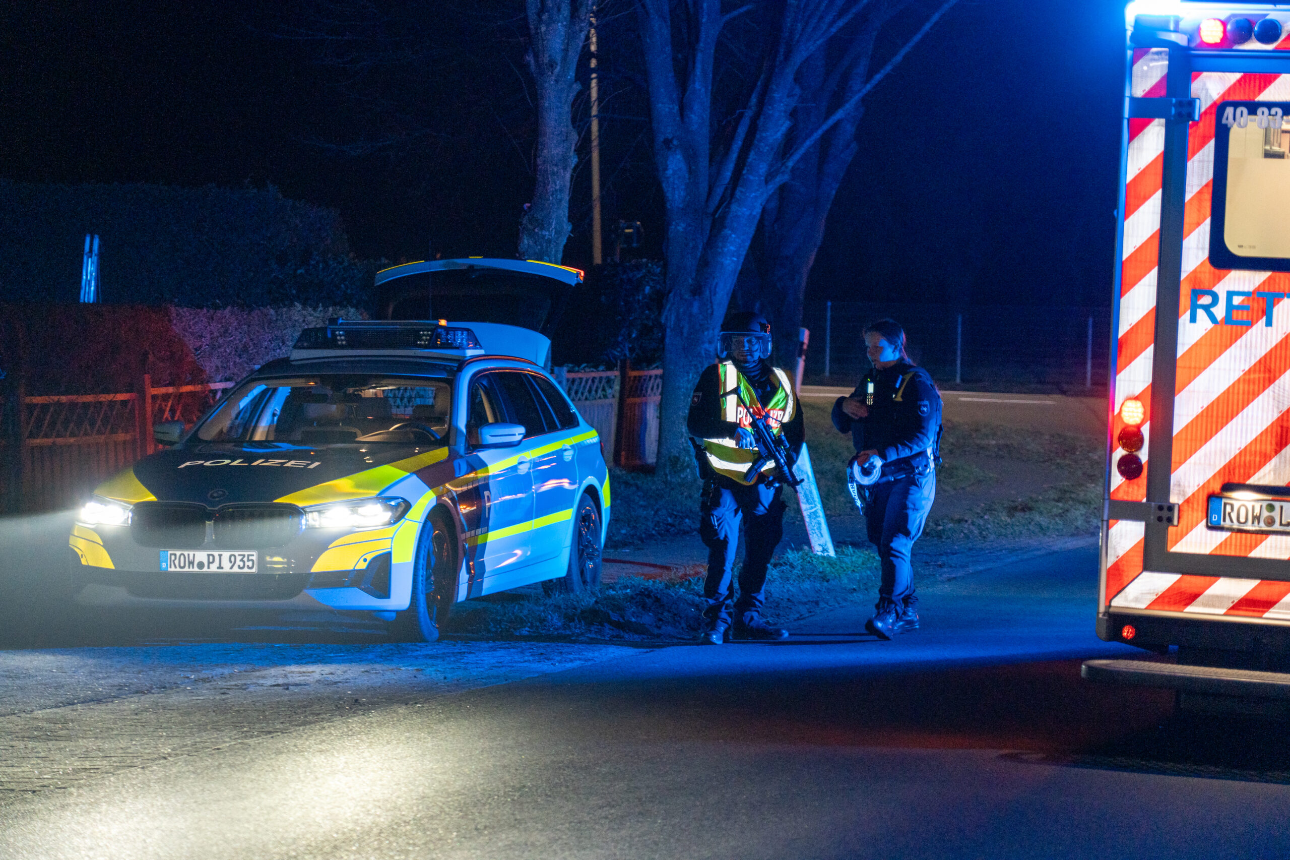 Zwei Polizisten, ein Polizei- und ein Rettungswagen am Einsatzort in Scheeßel