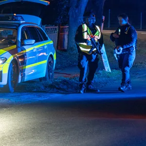 Zwei Polizisten, ein Polizei- und ein Rettungswagen am Einsatzort in Scheeßel