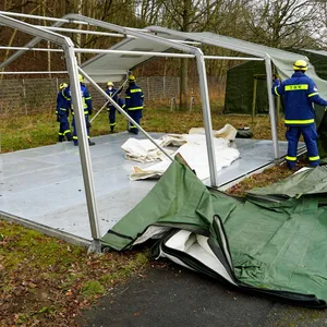 Männer vom THW bauen Zelte für die Erstunterbringung von Geflüchteten auf.