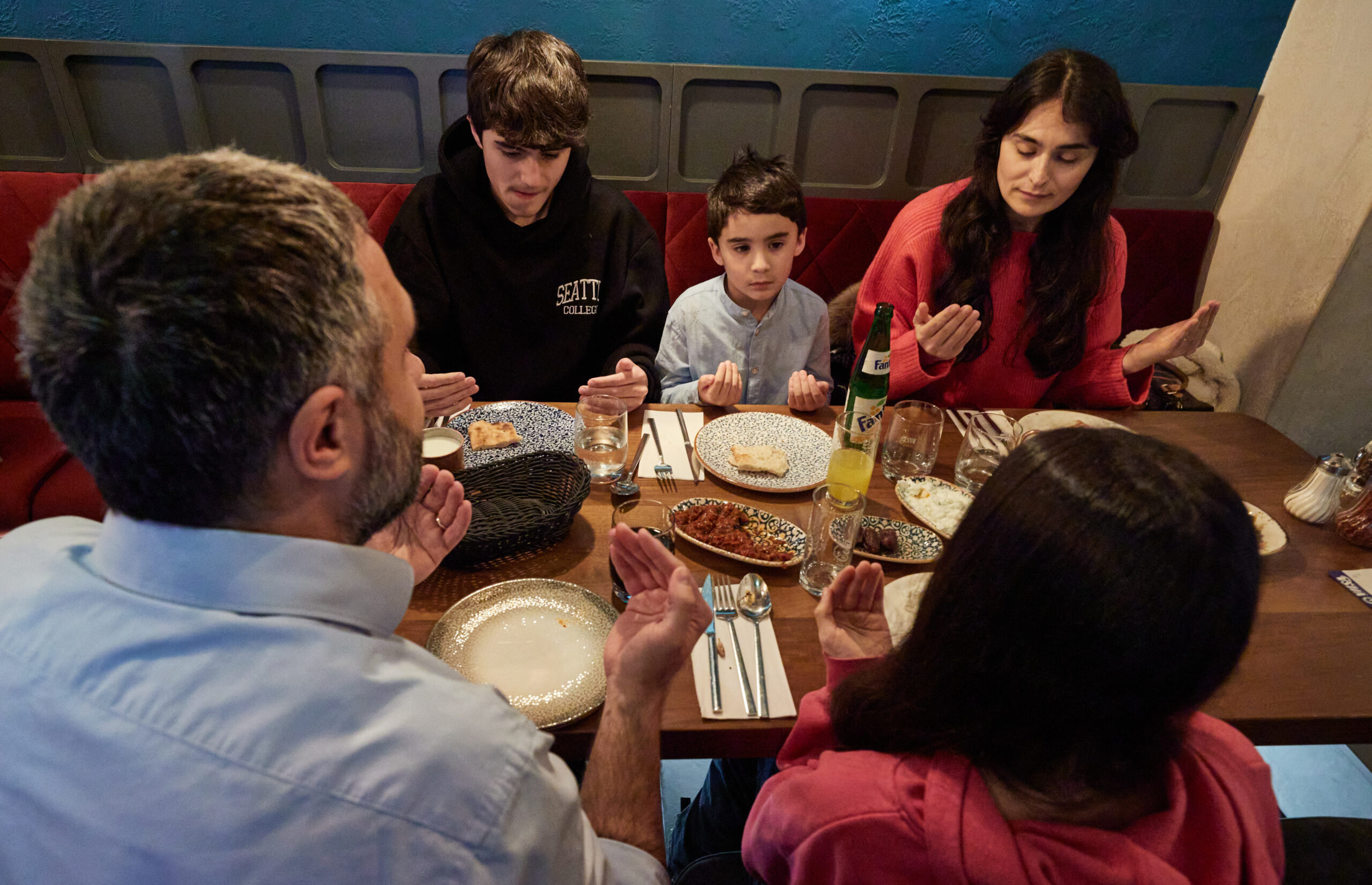 Eine muslimische Familie aus Hamburg spricht während des Fastenbrechens im Jahr 2023 ein Tischgebet.