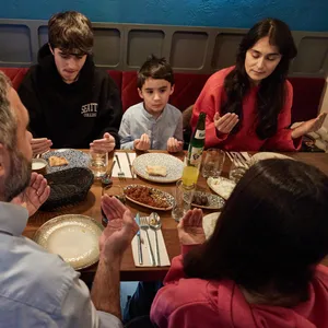 Eine muslimische Familie aus Hamburg spricht während des Fastenbrechens im Jahr 2023 ein Tischgebet.