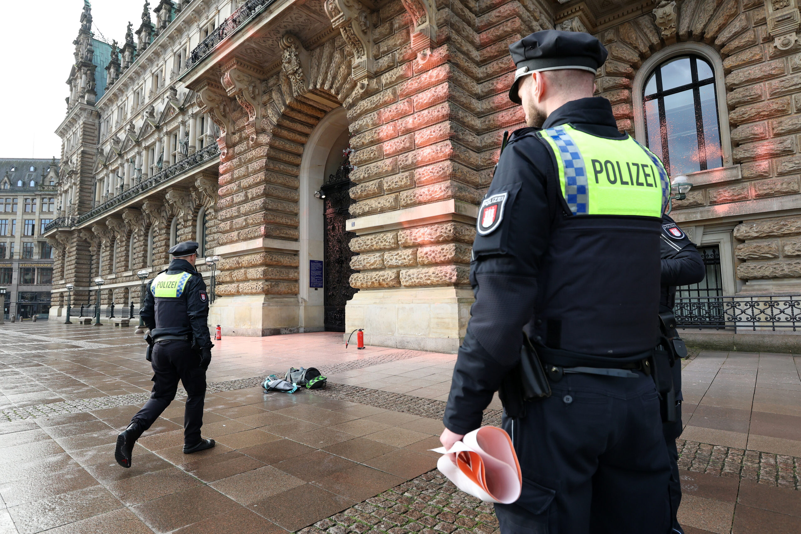 Polizisten vor beschmiertem Rathaus