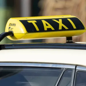 EIn Taxi-Schild über einem Taxi.