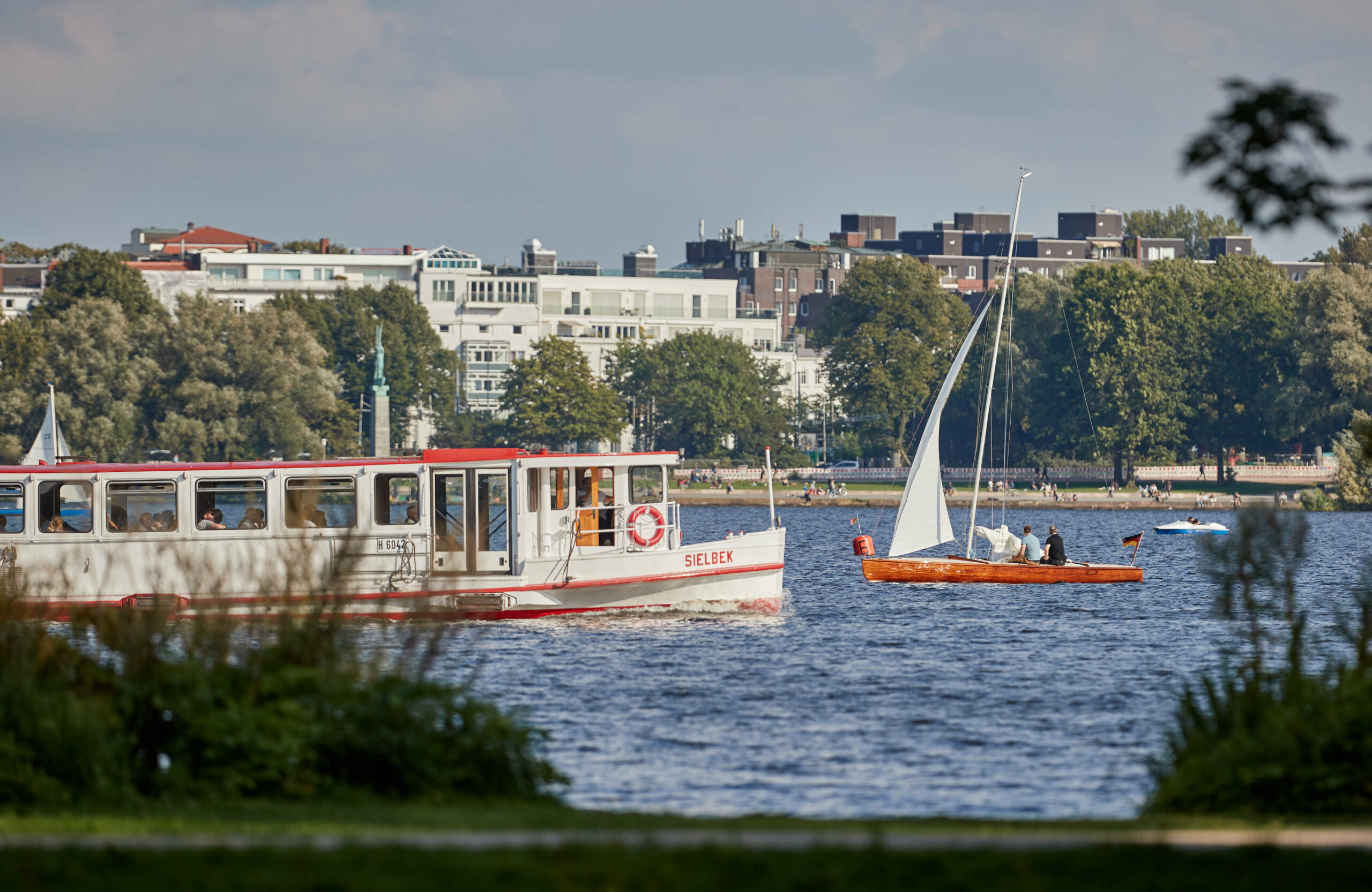 Die „Sielbek“, eines von 18 Schiffen der Alter Touristik, fährt bei sommerlichem Wetter auf der Alster (Archivbild).