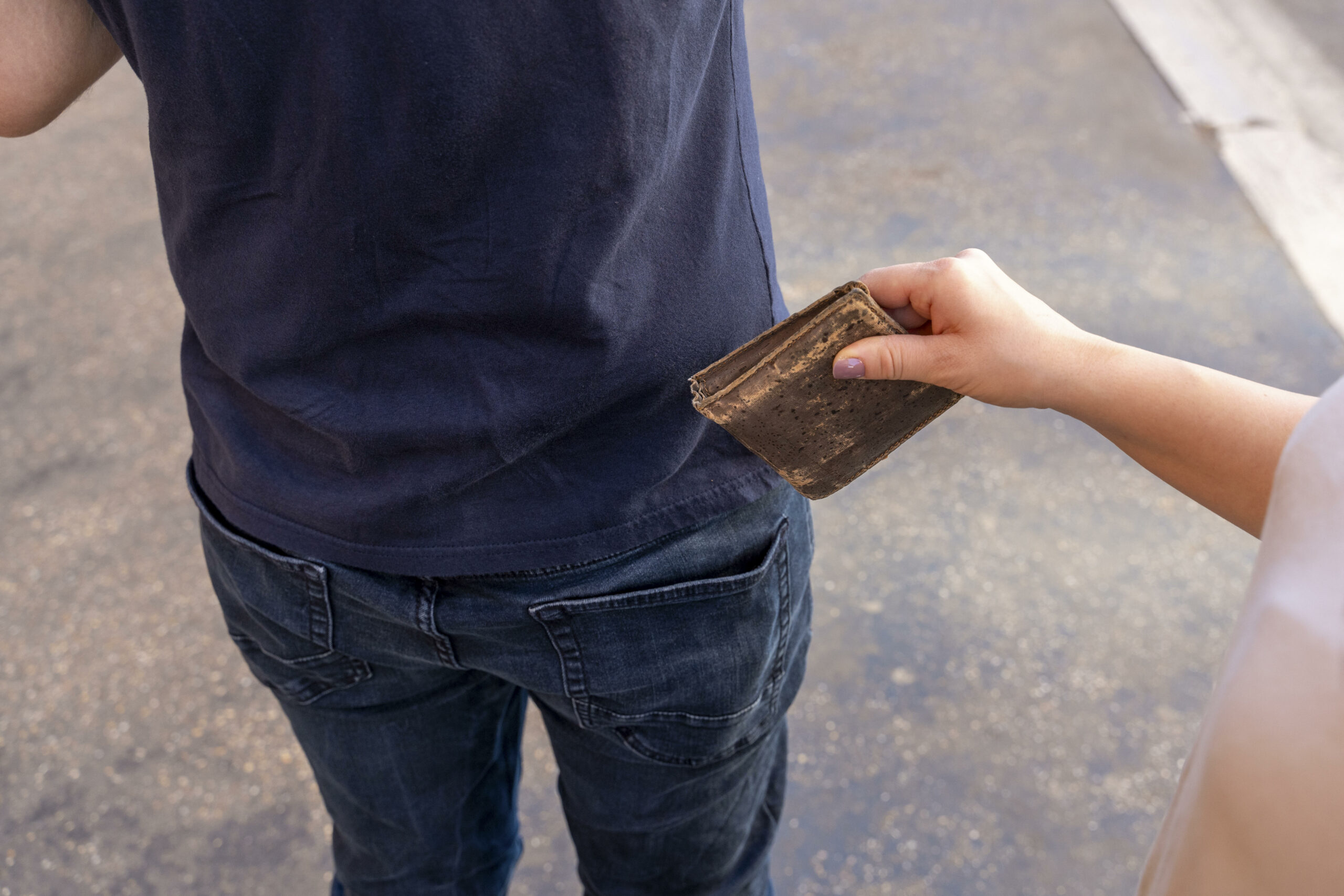 Jemand stiehlt einem Mann ein Portemonnaie aus der Hosentasche (Symbolbild).