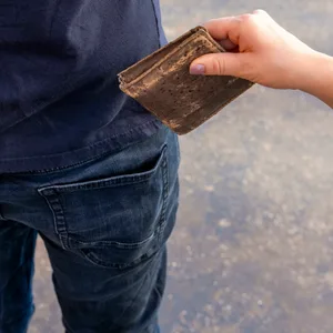 Jemand stiehlt einem Mann ein Portemonnaie aus der Hosentasche (Symbolbild).