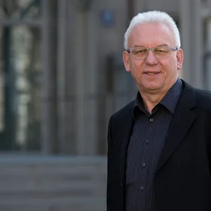 Mann in Sakko vor Gebäude
