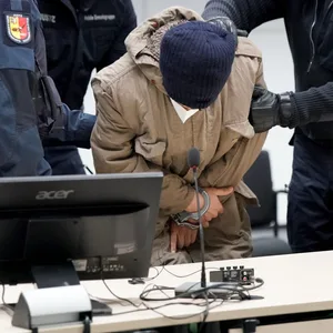Der Angeklagte Ibrahim A. (M) wird in Handschellen in den Gerichtssaal gebracht.