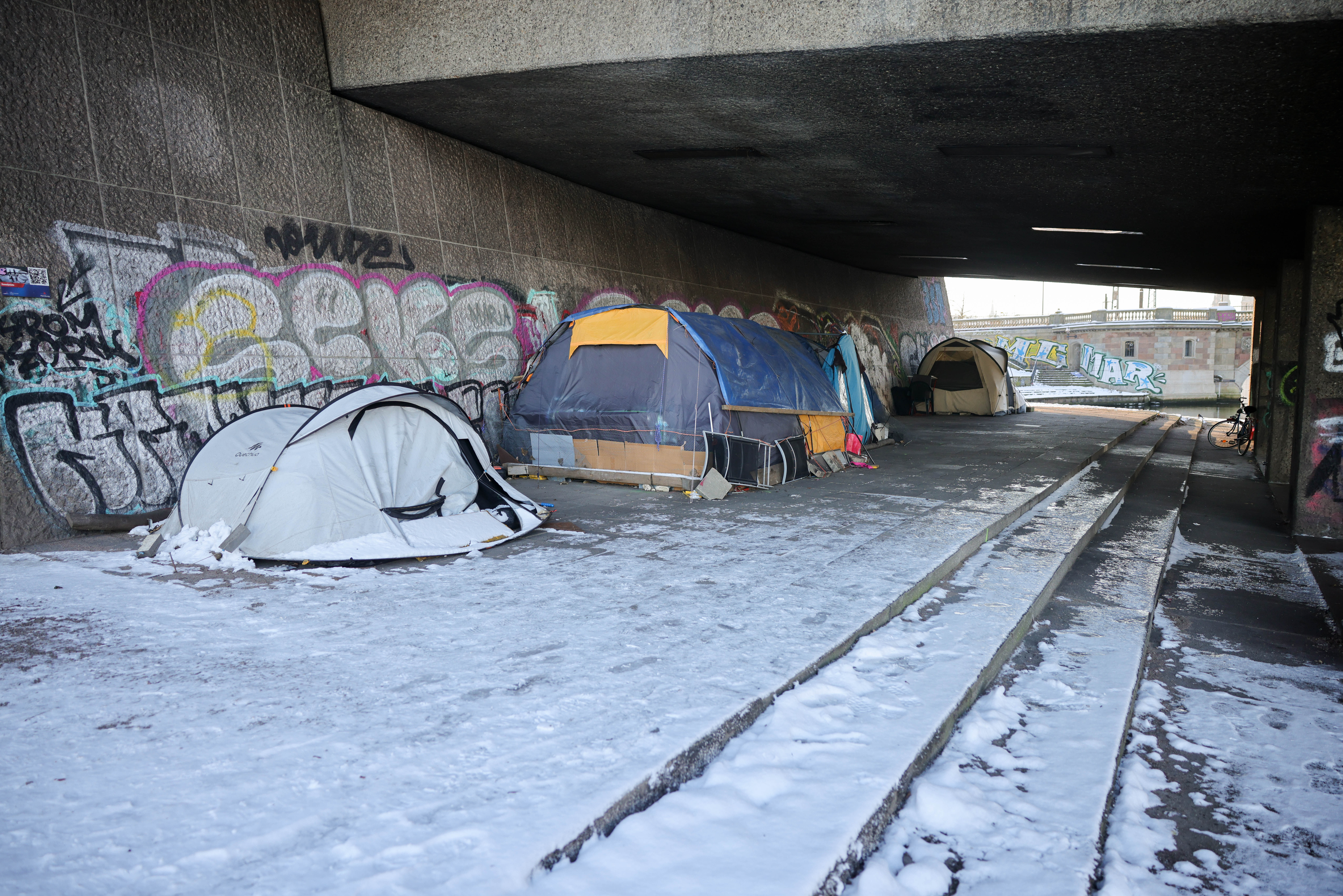 Zelte im Schnee unter einer Brücke