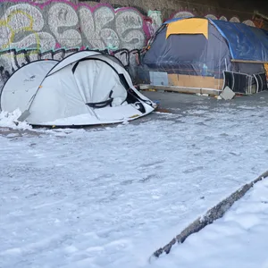 Zelte im Schnee unter einer Brücke