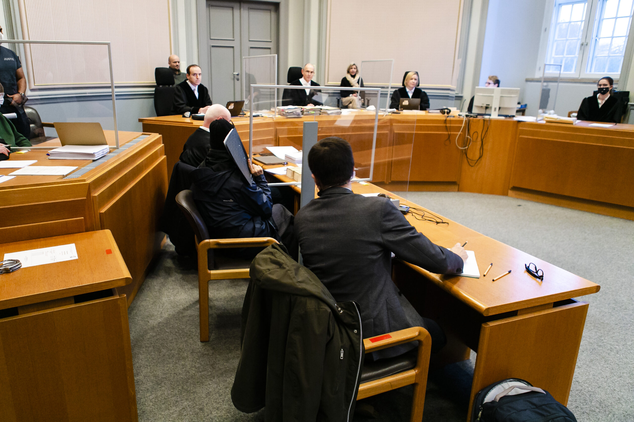 Prozessteilnehmer sitzen im Schwurgerichtssaal im Landgericht Kiel. Mittig im Hintergrund sitzt der Vorsitzende Richter Carsten Tepp.