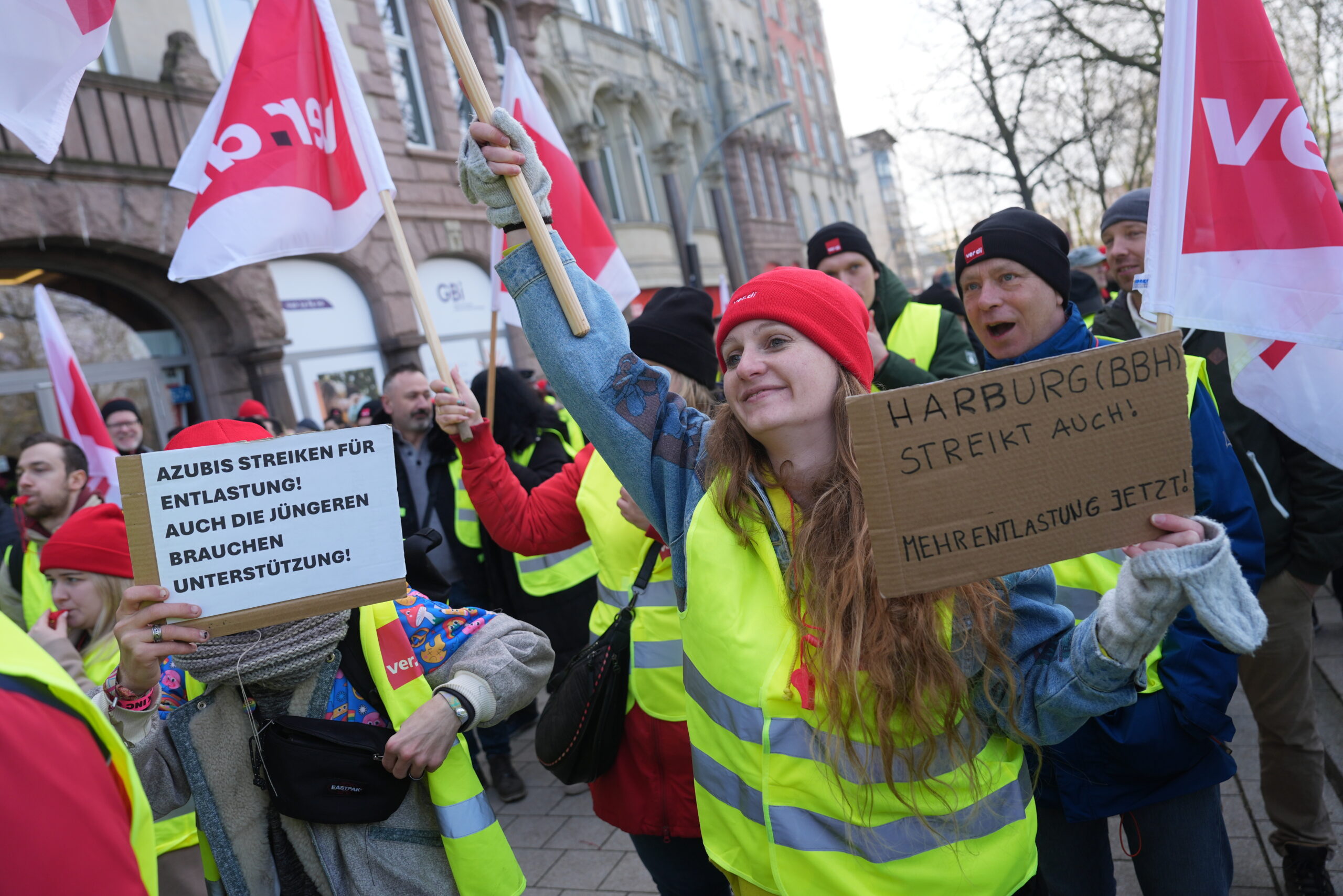 Streikende halten Schilder wie „Jugend entlasten“ hoch. Sie haben Warnwesten an und schwenken Verdi-Fahnen.