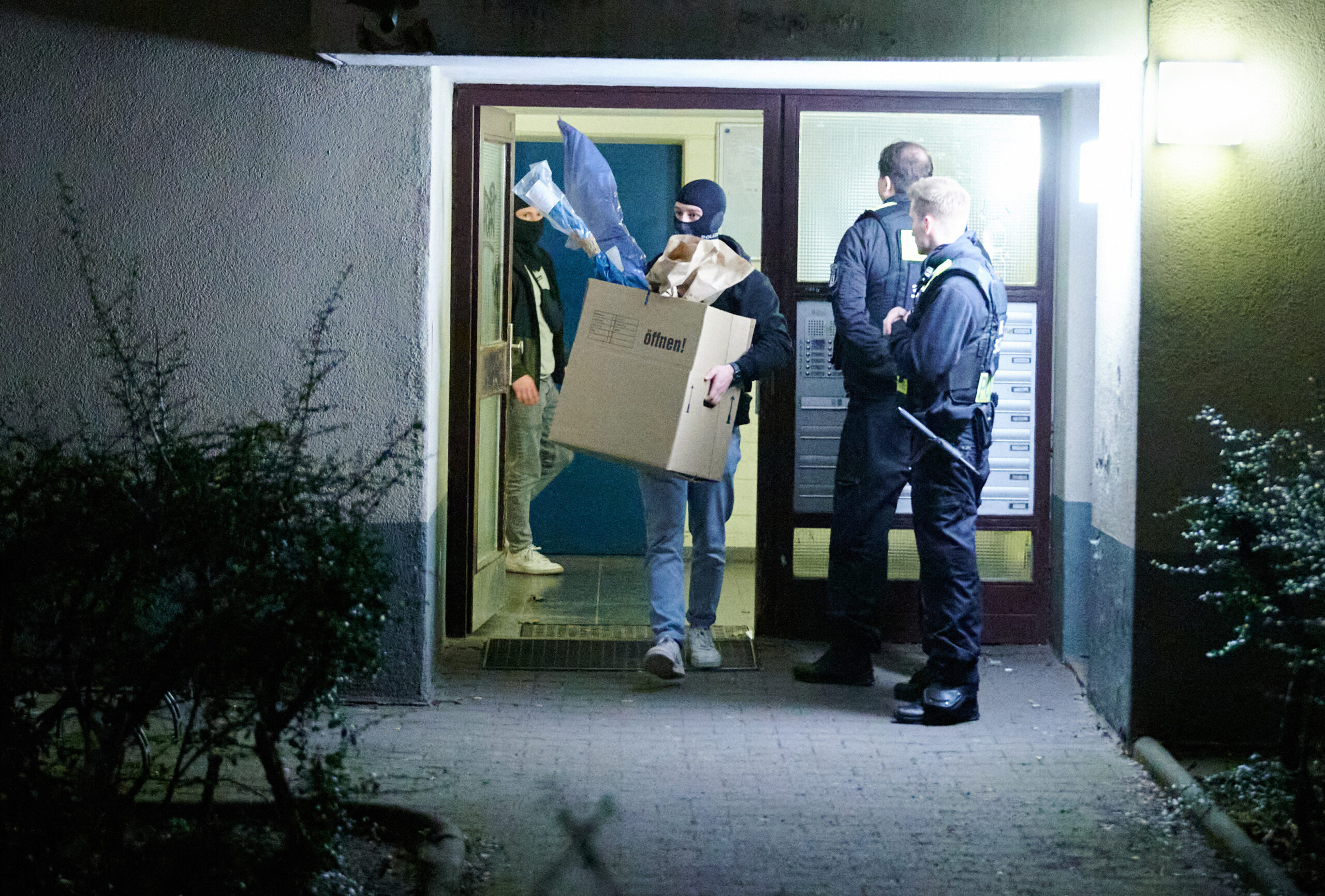 Mitarbeiter der Spurensicherung und des LKAs tragen Kisten aus dem Wohnhaus der früheren RAF-Terroristin Daniela Klette in Berlin-Kreuzberg.