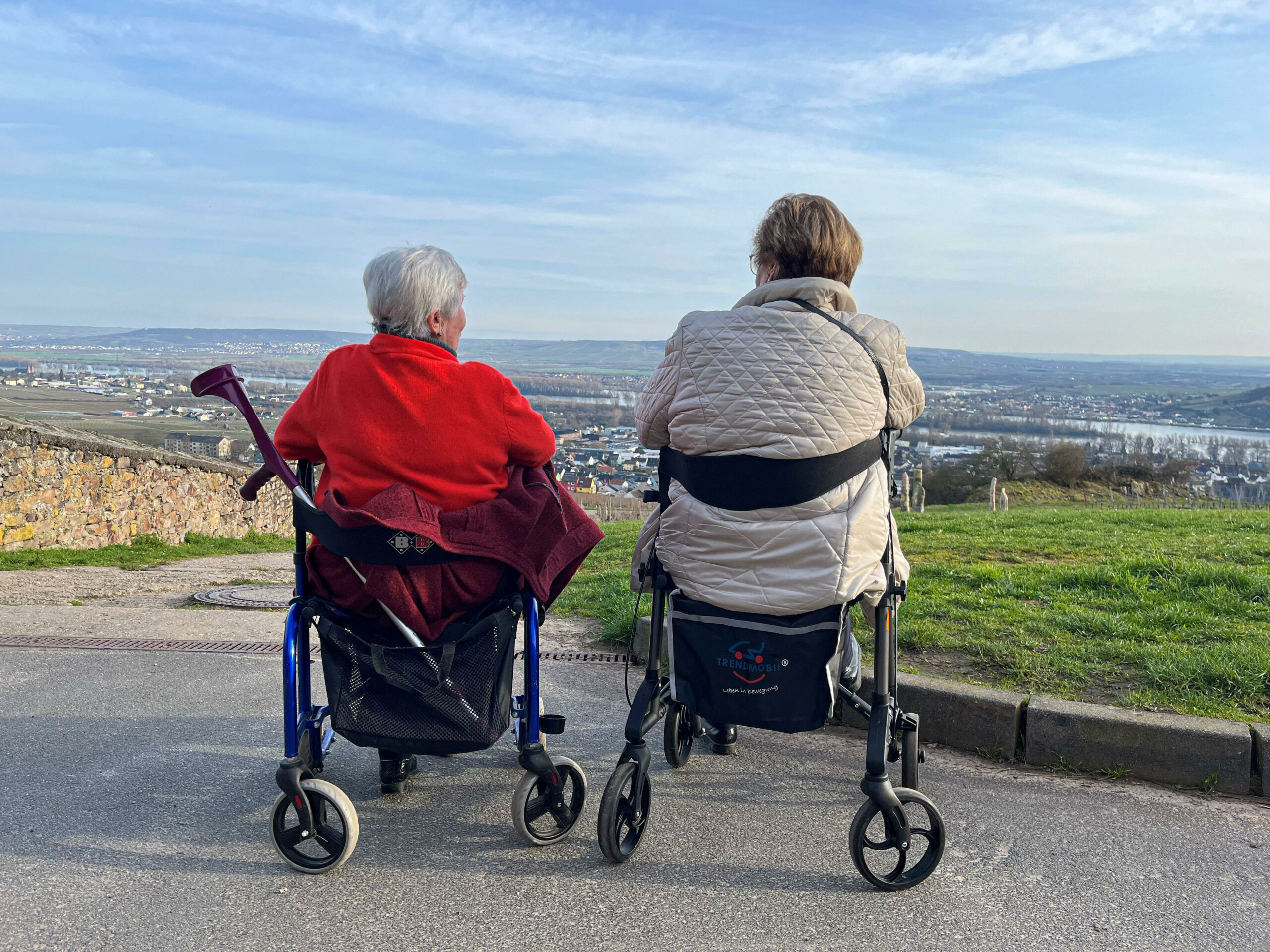 Zwei Rentnerinnen sitzen in ihren Rollatoren auf einem Berg.