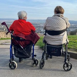 Zwei Rentnerinnen sitzen in ihren Rollatoren auf einem Berg.