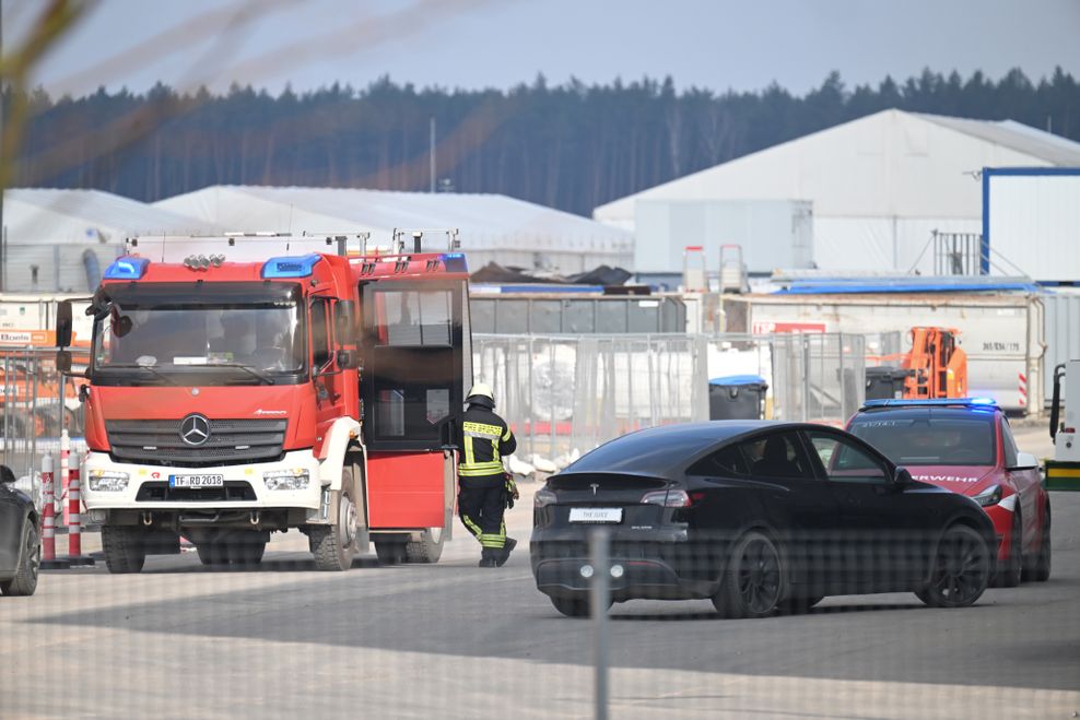 Fahrzeuge der Feuerwehr und Werkfeuerwehr stehen auf dem Gelände der Tesla-Autofabrik in Grünheide.