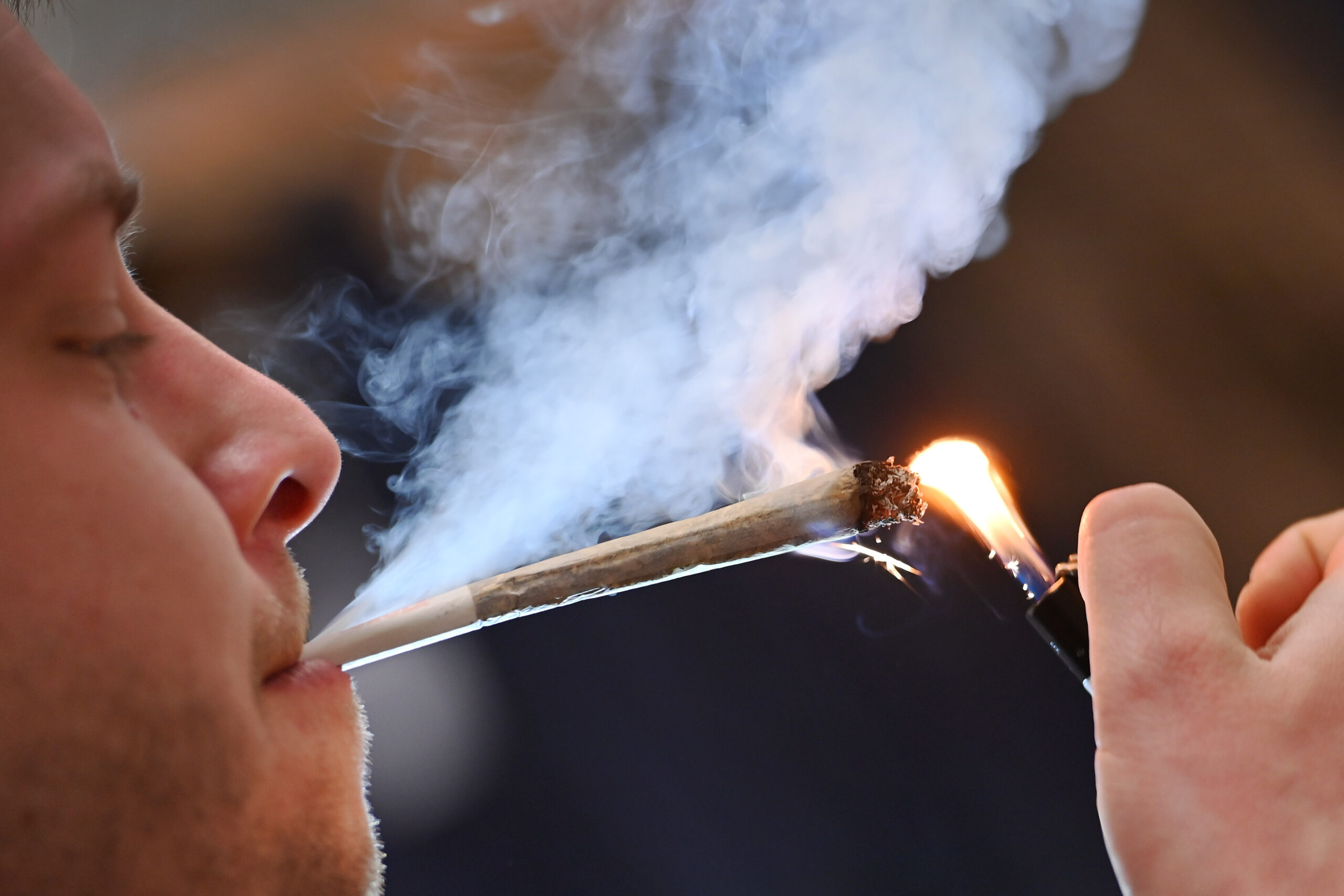Ein junger Mann raucht einen Joint.
