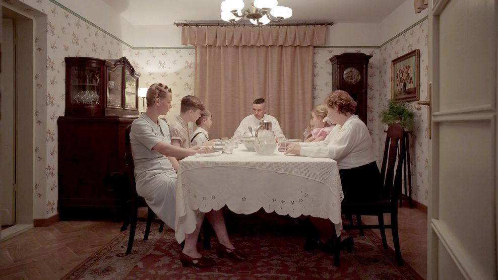 Familie Höß mit Sandra Hüller (l.) als Hedwig Höß und Christian Friedel (m.) als Rudolf Höß sitzt am Esstisch in einer Szene des Films „The Zone of Interest“ Bei den Oscars gewinnt das Drama als bester internationaler Film. 