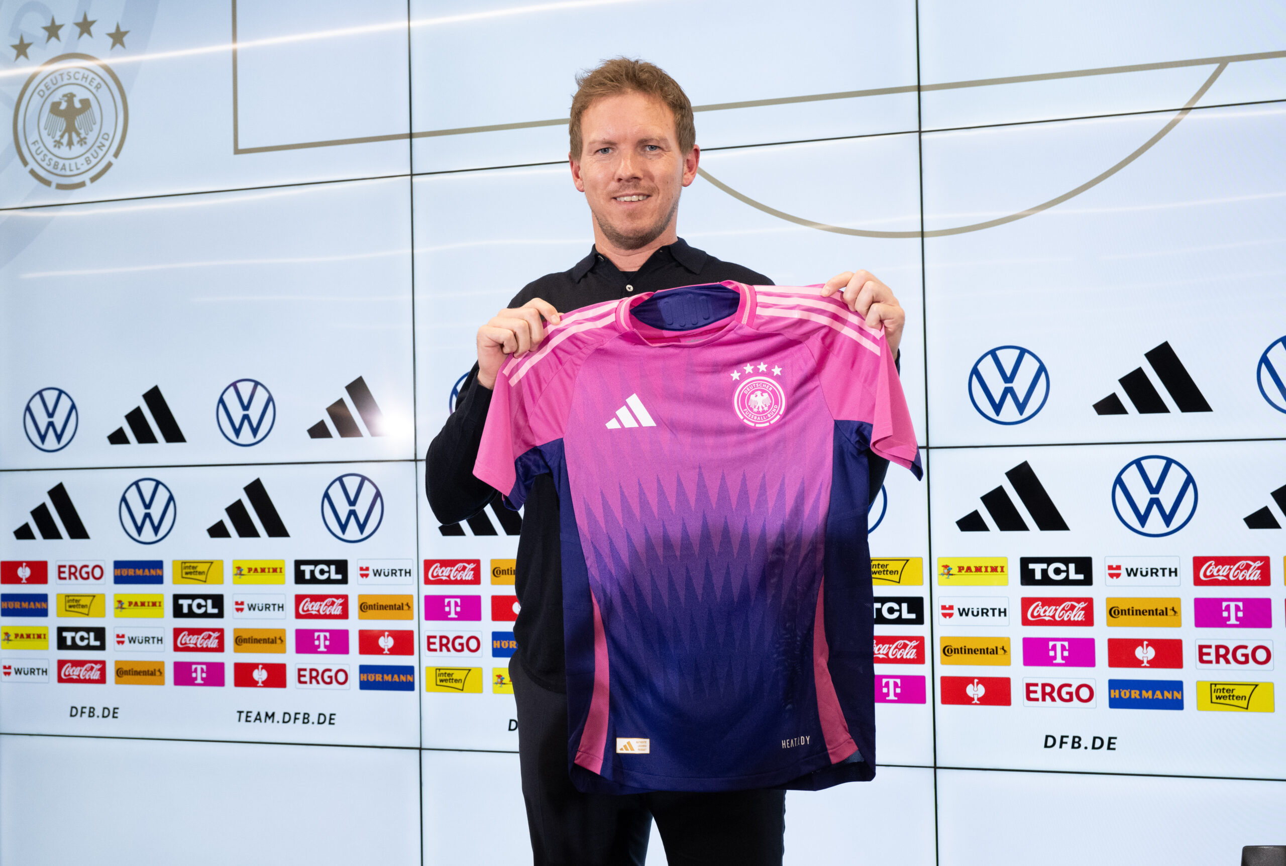 Julian Nagelsmann hält das neue DFB-Trikot in pinker Farbe hoch