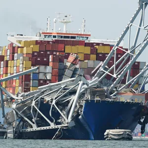 Ein Containerschiff steckt unter einem Teil der Francis Scott Key Bridge fest, nachdem es die Brücke gerammt hat.