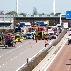 Diverse Einsatzfahrzeuge und mehrere Rettungshubschrauber an der Unfallstelle auf der A9 bei Leipzig.