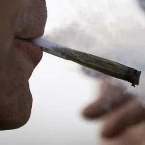 Ein Mann raucht einen Joint.