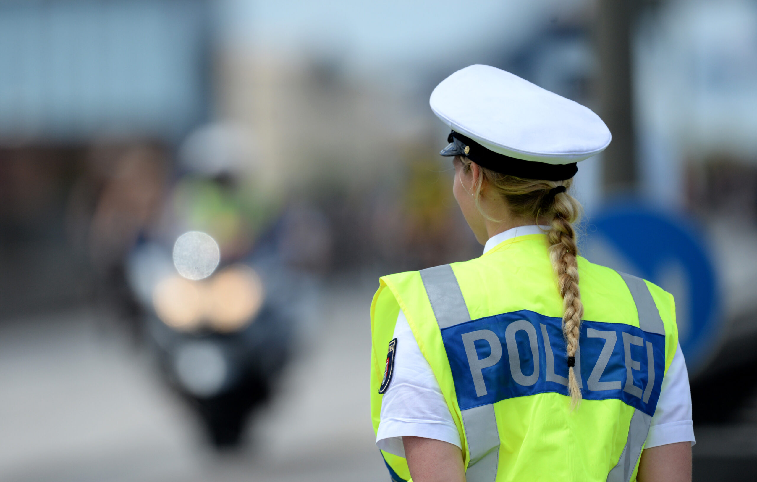 Eine Polizistin steht in Hamburg an einer Straße (Symbolfoto).