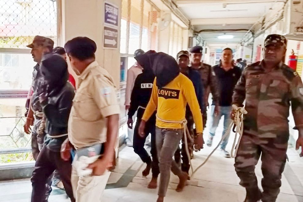 Beamte der indischen Polizei eskortieren die drei Festgenommenen zu einem Gerichtstermin.