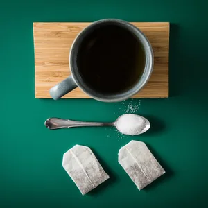 Tasse Tee, ein Löffel mit Zucker und zwei Teebeutel