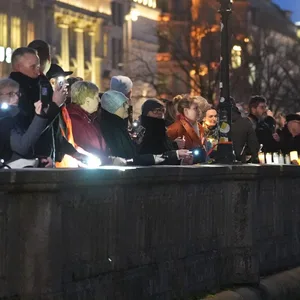 Teilnehmer halten leuchtende Handys und Taschenlampen während der Menschenkette gegen Rassismus an der Hamburger Binnenalster hoch.