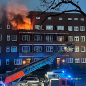 Flammen schlagen aus der Wohnung im vierten Stock.