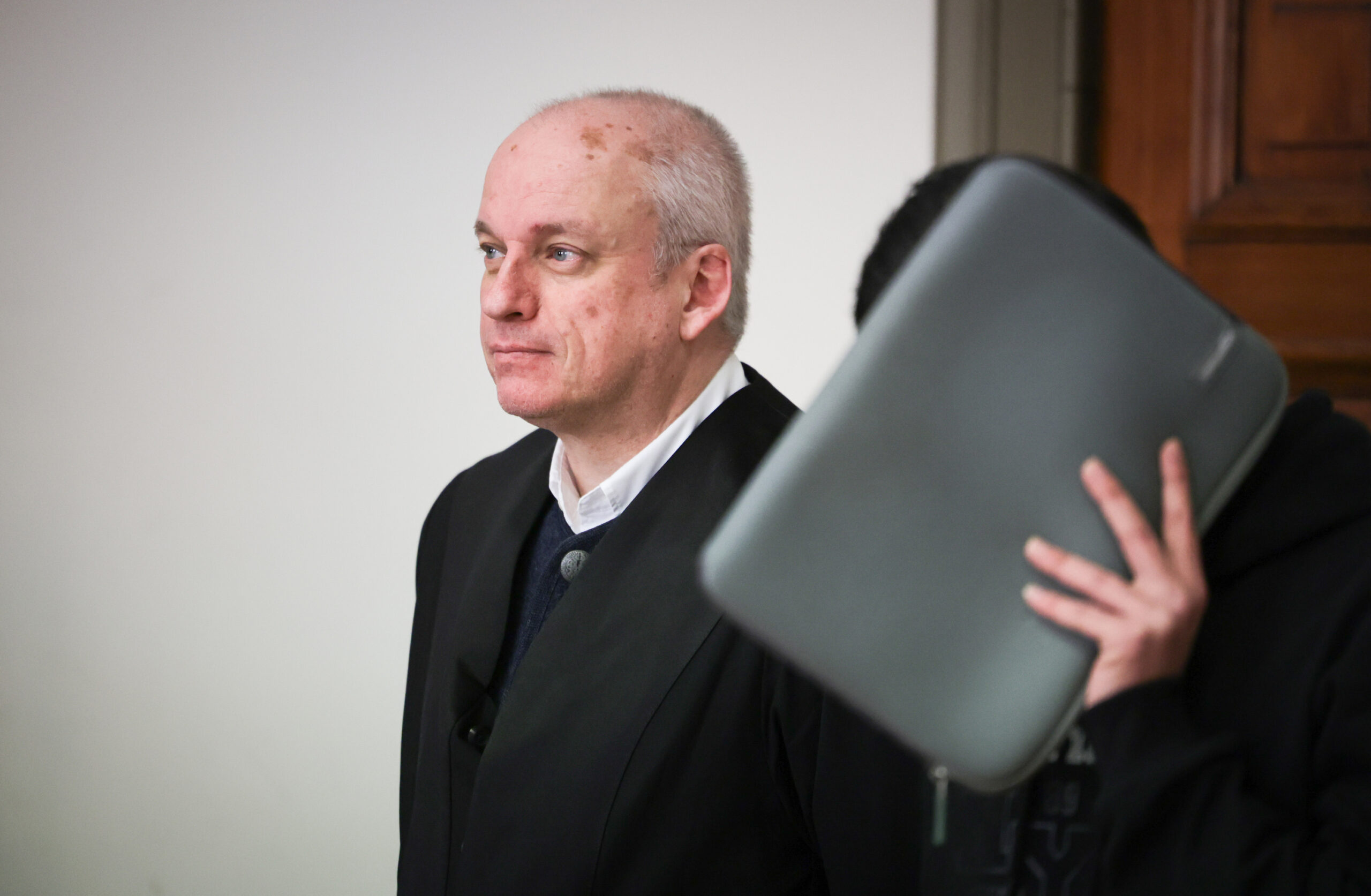 Der 20-jährige Angeklagte, der sich eine Tasche vors Gesicht hält, neben seinem Verteidiger vor dem Hamburger Landgericht.