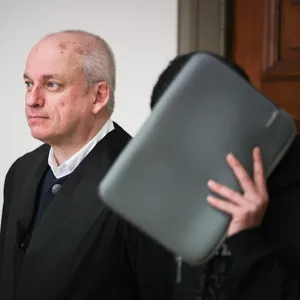 Der 20-jährige Angeklagte, der sich eine Tasche vors Gesicht hält, neben seinem Verteidiger vor dem Hamburger Landgericht.