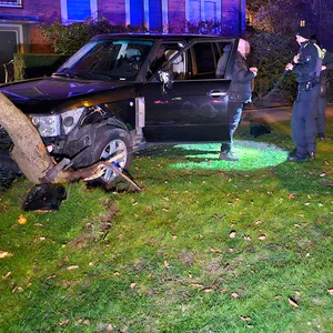 Auf den Schreck erstmal eine Zigarette: Der 58-jährige Fahrer steht mit Polizisten am Unfallwagen.