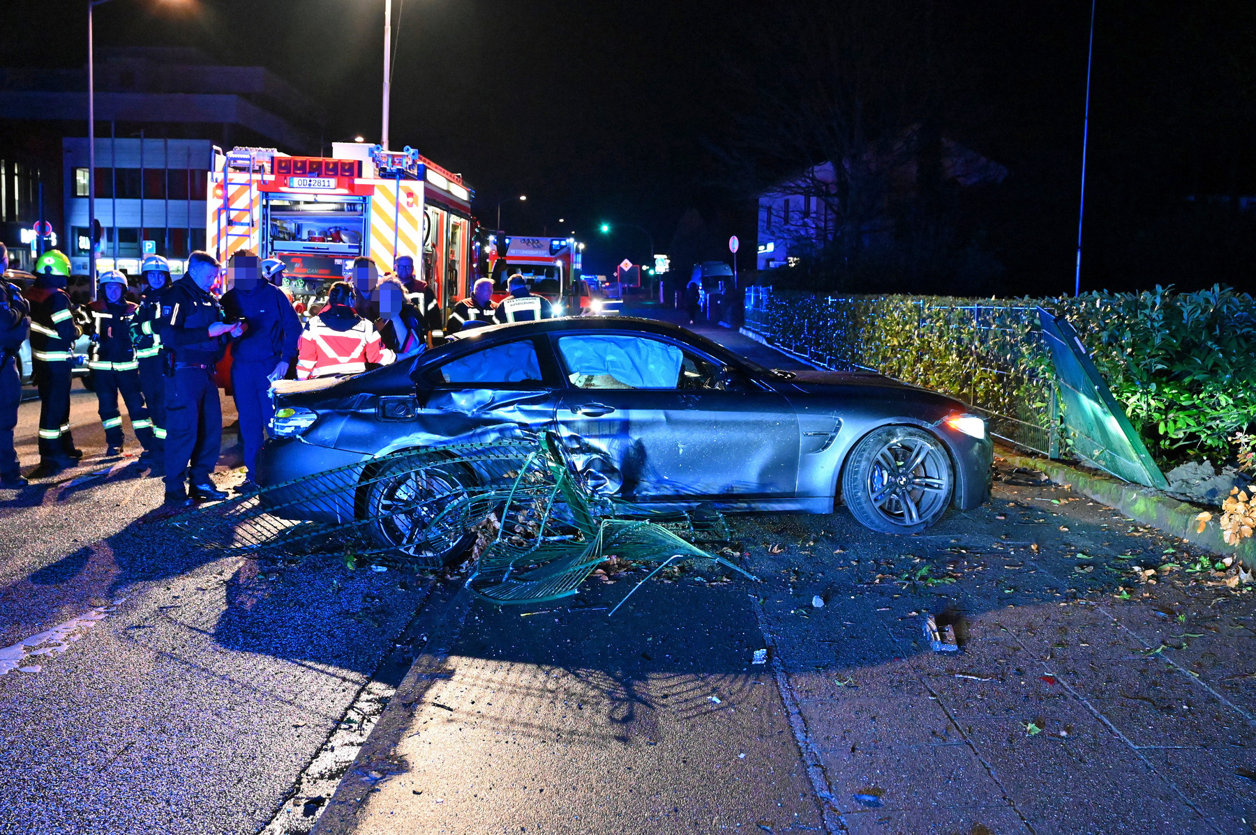 Polizisten begutachten den BMW und den Schaden, den der Fahrer verursachte.