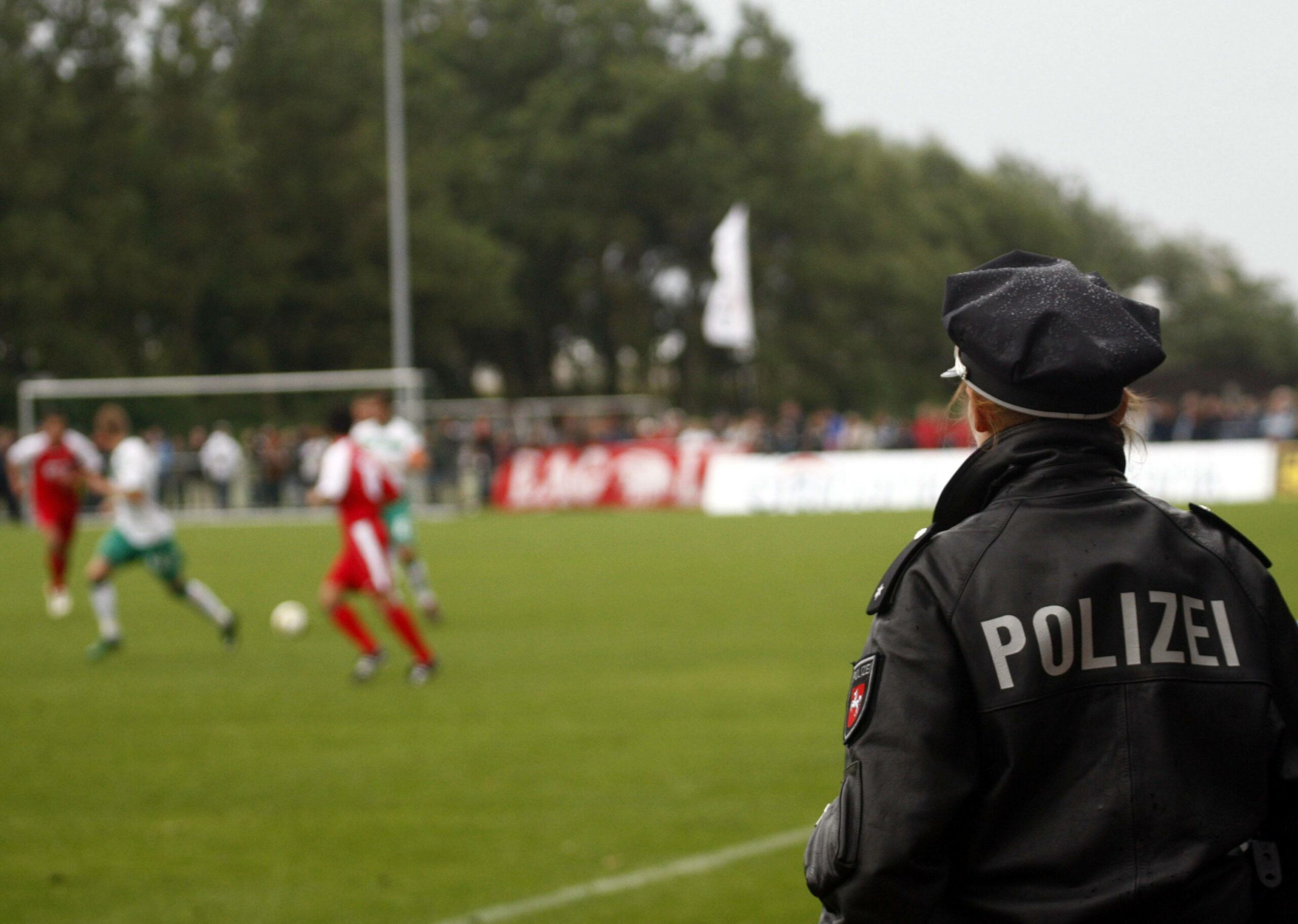 Polizistin beobachtet Amateur-Fußballspiel